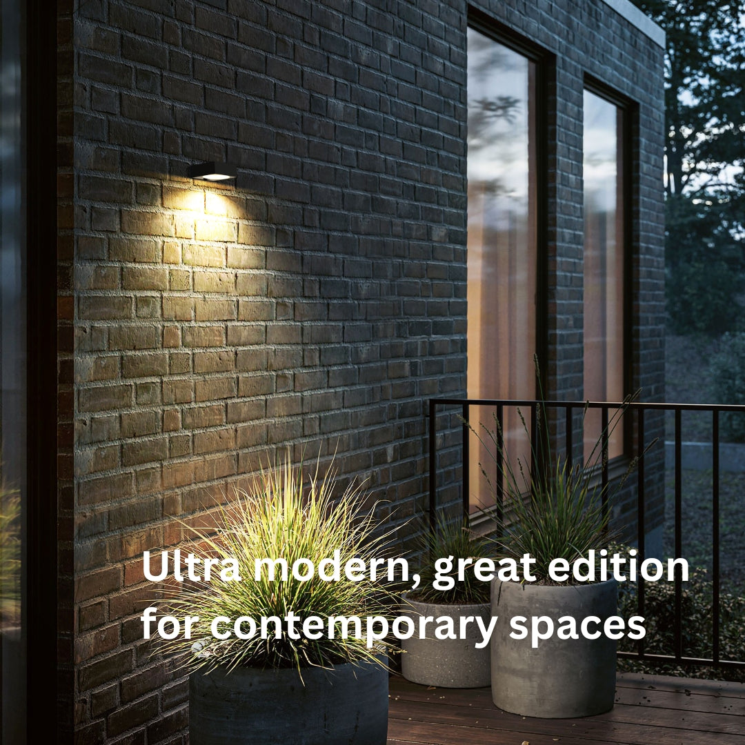 Modern outdoor setting with a brick wall, plants, and a solar wall light fixture.